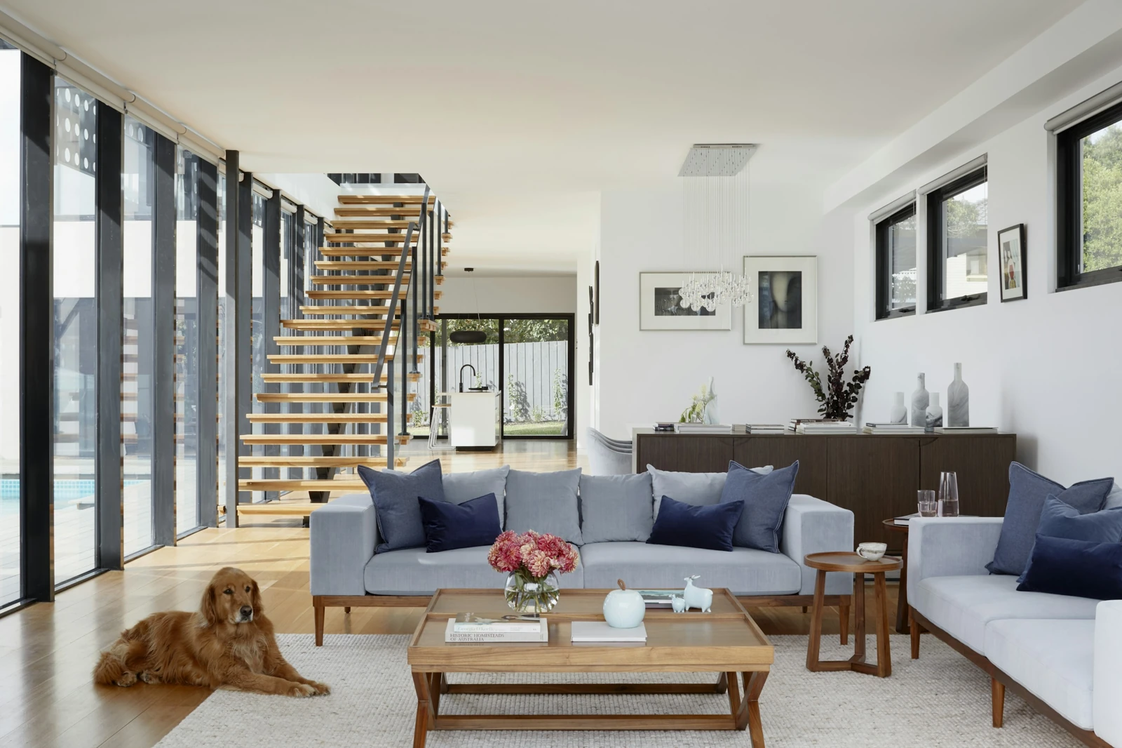 Residenza luminosa con scala sospesa, ampie vetrate e zona living contemporanea